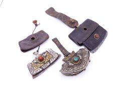 THREE TIBETAN CHUCKMUCK OR MECHAG TINDER POUCHES WITH FLINT IRON, EACH VARIOUSLY MOUNTED IN SILVER