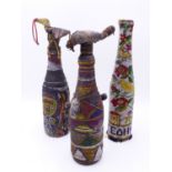 TWO TRIBAL BEAD WORK ENCASED GLASS BOTTLES WITH STOPPERS AND LATER FOLK ART EXAMPLE. (3)