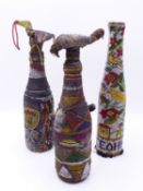 TWO TRIBAL BEAD WORK ENCASED GLASS BOTTLES WITH STOPPERS AND LATER FOLK ART EXAMPLE. (3)