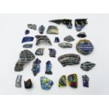 A COLLECTION OF TWENTY FIVE EGYPTIAN COLOURED AND DECORATED GLASS FRAGMENTS, THE LARGEST APPROX 10