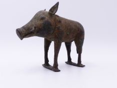 AN ARCHAISTIC BRONZE FIGURE OF A PIG CAST WITH DECORATED NECK GARLAND AND ACCENTUATED EYE BROWS.