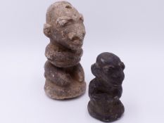 TWO TRIBAL CARVED STONE FIGURES, EACH KNEELING WITH ARMS FOLDED. LARGEST 18 CM HIGH.