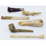 A CARVED GREEN HARDSTONE TOBACCO PIPE, THREE BONE CHEROOT HOLDERS, A SILVER MOUNTED LOBSTER CLAW