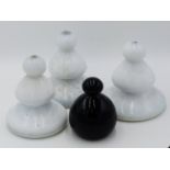 THREE VICTORIAN WHITE GLASS DOOR STOPS 17CM TALL TOGETHER WITH A SMALLER BLACK GLASS EXAMPLE.