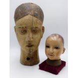 A 19TH CENTURY CARVED WOOD MANNEQUIN HEAD WITH PAINTED FEATURES TOGETHER WITH A HAND PAINTED WOOD