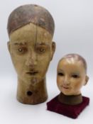 A 19TH CENTURY CARVED WOOD MANNEQUIN HEAD WITH PAINTED FEATURES TOGETHER WITH A HAND PAINTED WOOD