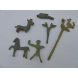 A BRONZE ARCHAIC FORM GARMENT PIN SURMOUNTED WITH BIRDS, A SIMILAR PIN AND FOUR FIGURAL AMULETS, THE
