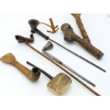 TWO NATURAL FORM WOODEN SMOKING PIPES, A LARGE SHAPED BAMBOO OPIUM PIPE, ANOTHER FOLK ART PIPE