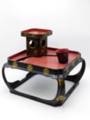 A JAPANESE TEA CEREMONY STAND AND ACCOUTREMENTS BLACK, RED AND GILT LACQUERED DECORATION. A