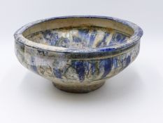 A LARGE ARCHAIC EASTERN POTTERY BOWL DECORATED IN GREEN AND BLUE THE GLAZE NOW WITH EVEN PEARLISED