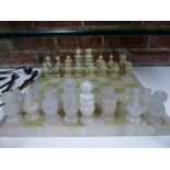 A CARVED ALABASTER CHESS SET OF TRADITIONAL FORM WITH GREEN/BROWN STRIATED AND OPAQUE WHITE PIECES