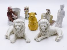 A PAIR OF CONTINENTAL WHITE GLAZED FIGURES OF RECUMBANT LIONS, AN EARLY POTTERY "PIGGY BANK", A