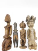 A GROUP OF WEST AFRICAN CARVED WOOD FIGURES TO INCLUDE TWO MATERNITY FEMALE FIGURES, A FIGURE OF A