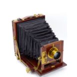 AN UN-NAMED VICTORIAN MAHOGANY AND BRASS BOUND 1/2 PLATE CAMERA, FITTED WITH COOKE LENS H.D. TAYLORS