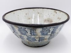 A LARGE ORIENTAL BLUE AND WHITE POTTERY BOWL WITH BAMBOO RE-ENFORCED RIM. 26CM DIAMETER