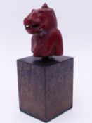 AN EGYPTIAN CARVED RED STONE BUST FRAGMENT OF SEKHMET, MOUNTED ON MUSEUM TYPE DISPLAY PLINTH. THE
