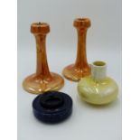 RUSKIN POTTERY, A PAIR OF ORANGE LUSTRE CANDLETICKS 16CM TALL TOGETHER WITH AN INKWELL HAVING DARK