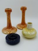 RUSKIN POTTERY, A PAIR OF ORANGE LUSTRE CANDLETICKS 16CM TALL TOGETHER WITH AN INKWELL HAVING DARK