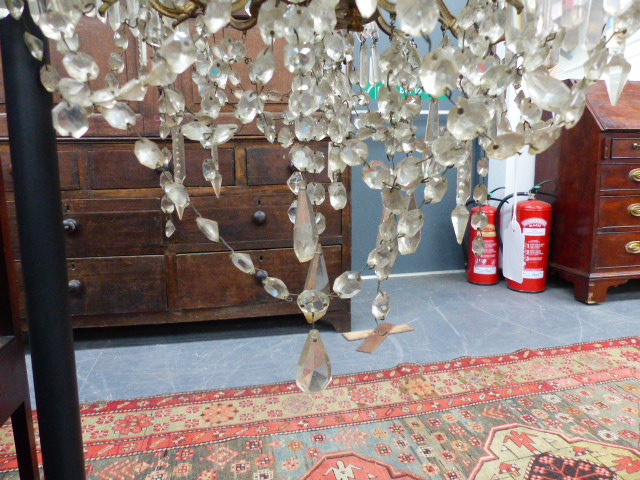 A VINTAGE FRENCH STYLE GILT BRASS FRAME NINE LIGHT CHANDELIER, FLOWER HEADS WITH SWAGS AND PRISMS - Image 3 of 9