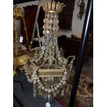 A VINTAGE REGENCY STYLE BRASS FRAME BASKET CHANDELIER HUNG WITH PRISMS AND SWAGS.