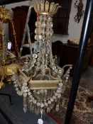 A VINTAGE REGENCY STYLE BRASS FRAME BASKET CHANDELIER HUNG WITH PRISMS AND SWAGS.