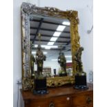 A LARGE VICTORIAN GILT ROCOCO STYLE FRAME WITH LATER SILVERED HIGHLIGHTS, NOW WITH A MIRROR PLATE.