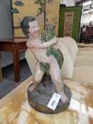 A 19TH CENTURY POLYCHROMED TERRA COTTA FIGURAL GROUP OF A BOY HOLDING A DOLPHIN. INSCRIBED HENRY