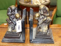 A PAIR OF BRONZE AND MARBLE BOOKENDS. EACH MOUNTED WITH A CHIMPANZEE HOLDING A SKULL SEATED ON A