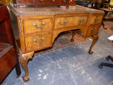 A GEORGIAN STYLE WALNUT WRITING DESK WITH FIVE DRAWERS ON CARVED CABRIOLE LEGS. 121cms WIDE.