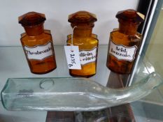 A GROUP OF THREE AMBER GLASS APOTHECARY BOTTLES WITH ENAMEL LABELS TOGETHER WITH A CLEAR GLASS