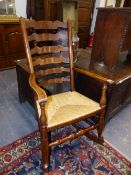 AN ANTIQUE ELM AND RUSH SEAT LADDER BACK ROCKING CHAIR.