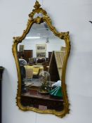 A CARVED GILTWOOD FRAMED WALL MIRROR. 117cms HIGH