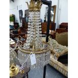 A REGENCY STYLE BRASS BASKET FORM CHANDELIER HUNG WITH PRISMS AND SWAGS