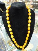 A BUTTERSCOTCH TYPE AMBER BEAD NECKLACE. 80CM LONG (EXCLUDING TASSEL). APPROXIMATELY 110 GRAMS