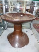 AN ANTIQUE TRIBAL DISH TOP STOOL