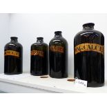 FOUR LARGE 19TH.C.GREEN GLASS APOTHECARY BOTTLES WITH GILT LABELS.