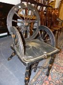 AN UNUSUAL EBONISED CHAIR CONSTRUCTED FROM SPINNING WHEELS WITH PAINTED DECORATION.