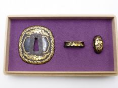 AN EDO PERIOD MATCHING TSUBA AND FUCHI KASHIRA SET. THE IRON TSUBA FILLED WITH SHAKUDO AND DECORATED