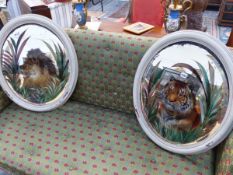 A PAIR OF ANTIQUE OVAL WALL MIRRORS WITH REVERSE PAINTING OF TIGER AND LION.