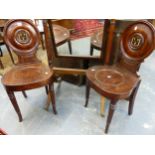 A GOOD PAIR OF LATE GEORGIAN MAHOGANY HALL CHAIRS WITH PAINTED ARMORIAL PANEL BACKS.