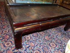 AN ORIENTAL EBONISED AND GILT LOW SQUARE TABLE, THE TOP DECORATED WITH PAVILLIONS IN A LANDSCAPE.