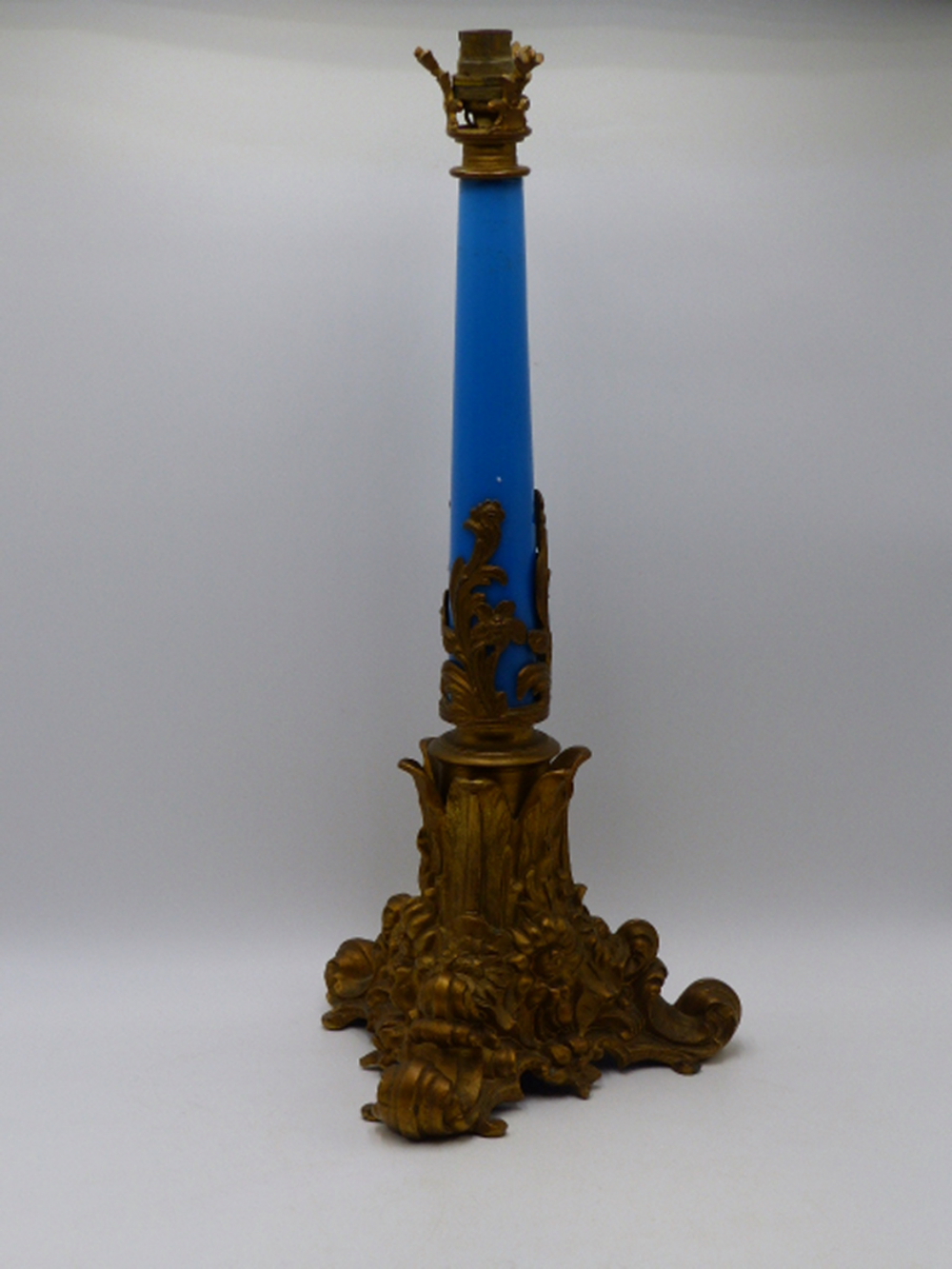 A LATE 19TH CENTURY FRENCH GILT METAL LAMP BASE WITH BLUE GLASS STEM AND SCROLLED FEET. (50CMS