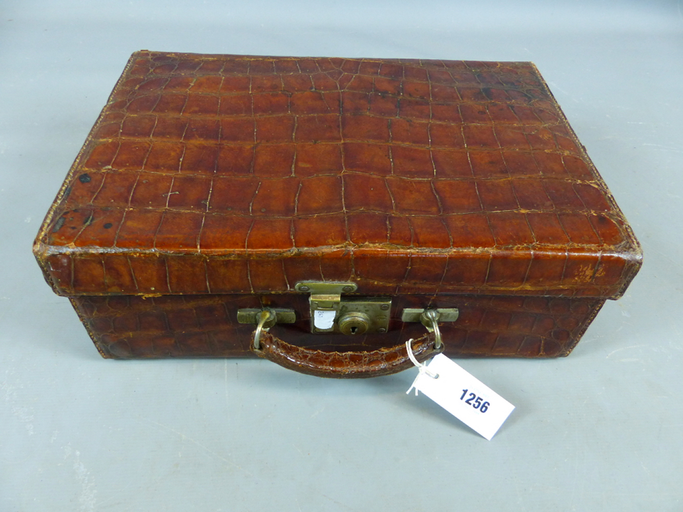 A CROCODILE SKIN TRAVELLING VANITY CASE FITTED WITH VARIOUS GLASS AND WHITE METAL DRESSING TABLE