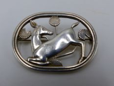 A DENMARK STERLING SILVER GEORG JENSEN BROOCH DEPICTING A KNEELING DEER DESIGNED BY ARNO