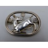 A DENMARK STERLING SILVER GEORG JENSEN BROOCH DEPICTING A KNEELING DEER DESIGNED BY ARNO