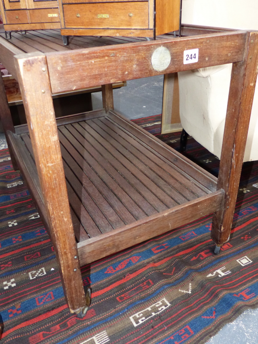 AN EARLY 20TH.C.TEAK TWO TIER SERVING TROLLEY, CONSTRUCTED FROM THE TIMBERS OF HMS ARETHUSA.