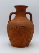 A VICTORIAN TERRACOTTA TWIN HANDLE VASE MODELLED AFTER THE PORTLAND VASE BY WEDGWOOD. 22.5CMS HIGH