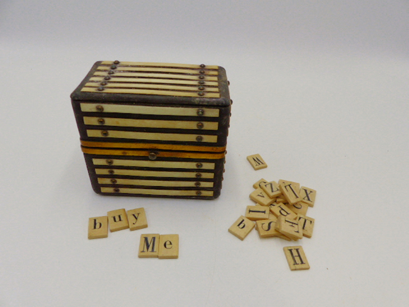 A LATE GEORGIAN SMALL TABLE CASKET WITH IVORY AND GILKT BRASS MOUNTS CONTAINING A SELECTION OF