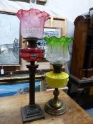 A 19TH.C.OIL LAMP WITH CRANBERRY GLASS RESERVOIR AND SHADE AND A FURTHER VICTORIAN OIL LAMP WITH