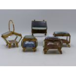 A SELECTION OF FIVE GLASS AND GILT METAL JEWELLERY CASKETS. (SMALLEST ONE BEING APPROX 6 CMS WIDE).